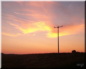 Himmel in gelb und rot &uuml;ber einem Strommast
